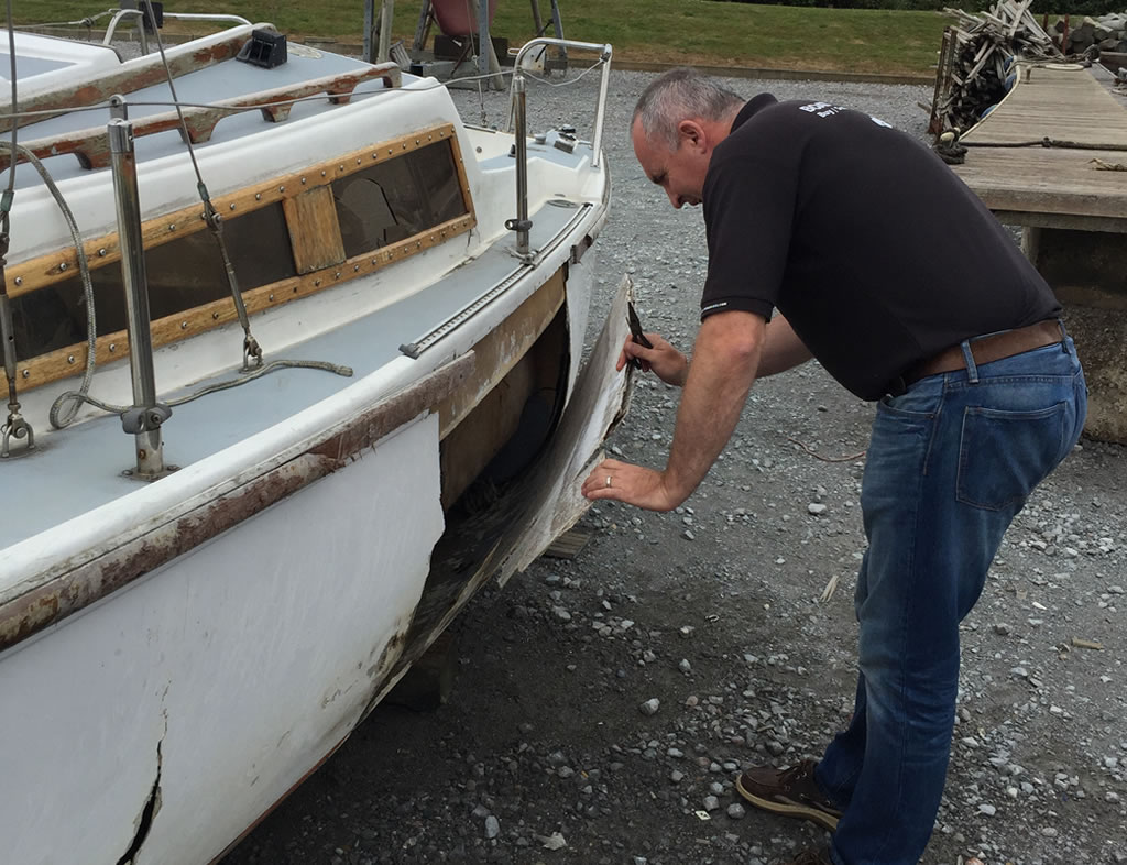 Boat Salvage - An Old Yacht being inspected for damage